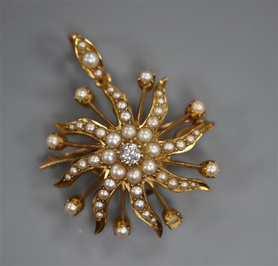 A diamond, seed pearl and gold (tests as 14ct) starburst brooch-cum-pendant (one pearl missing), 31mm.